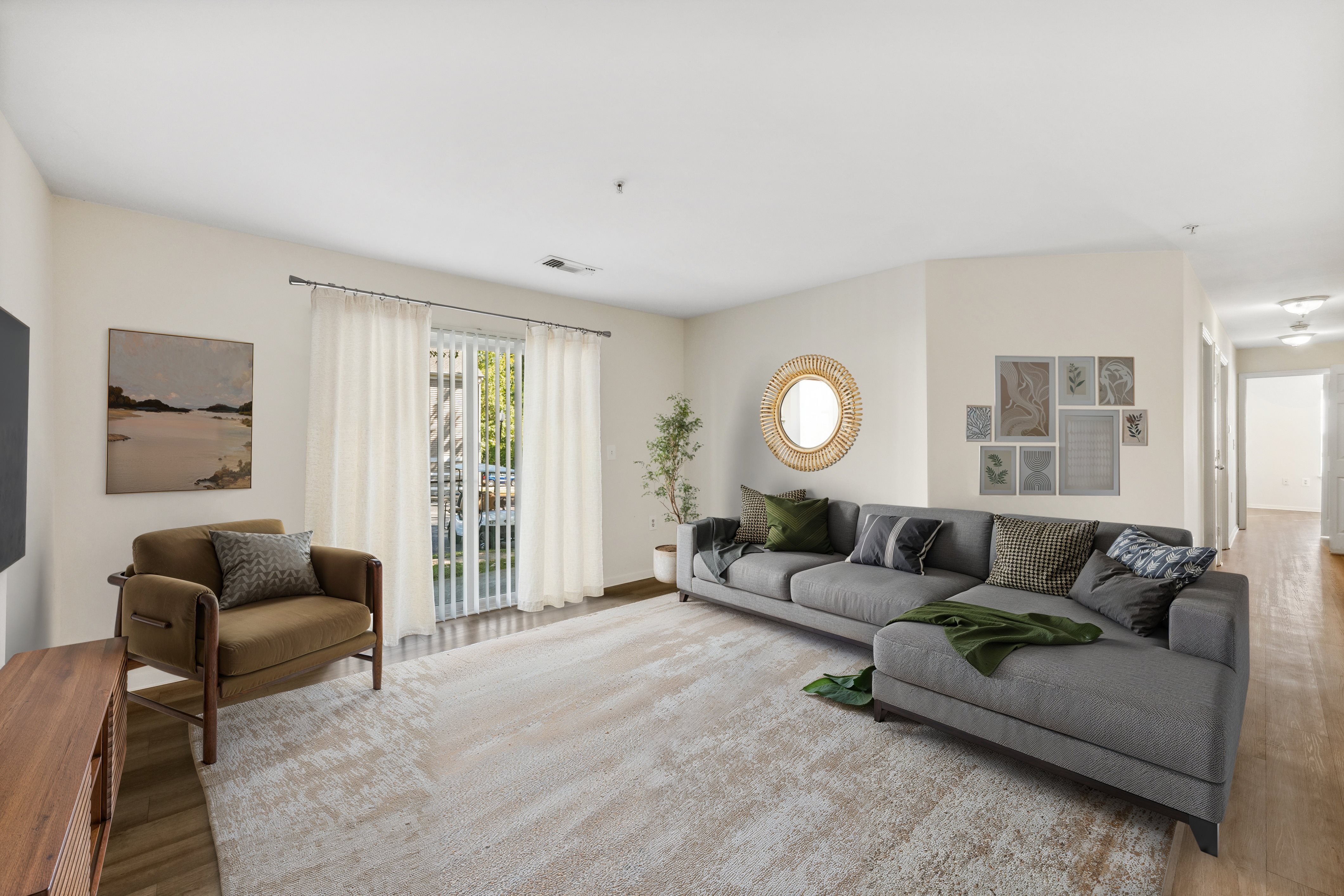 A living room with a grey couch and a wooden table.